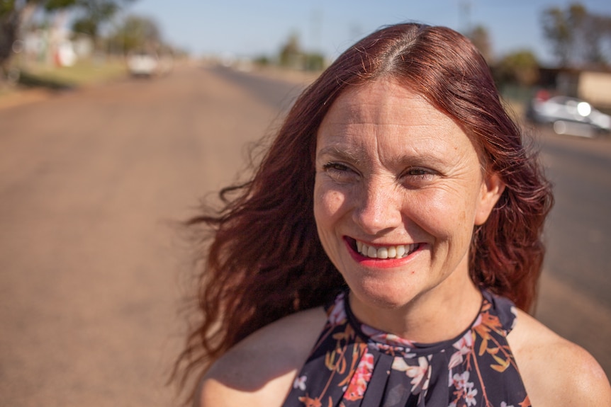 A woman stares off camera, laughing.