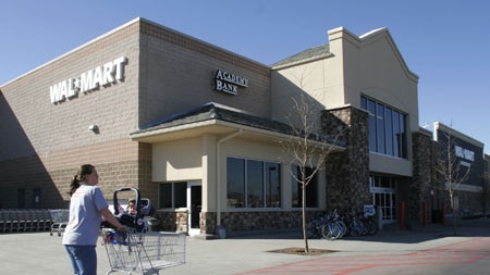 Woman with trolley walks past Wal-Mart store