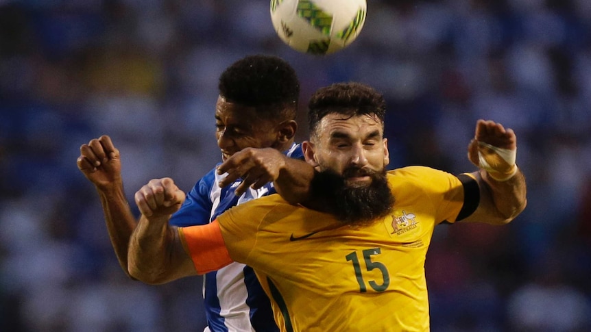 Mile Jedinak contests the ball against Honduras