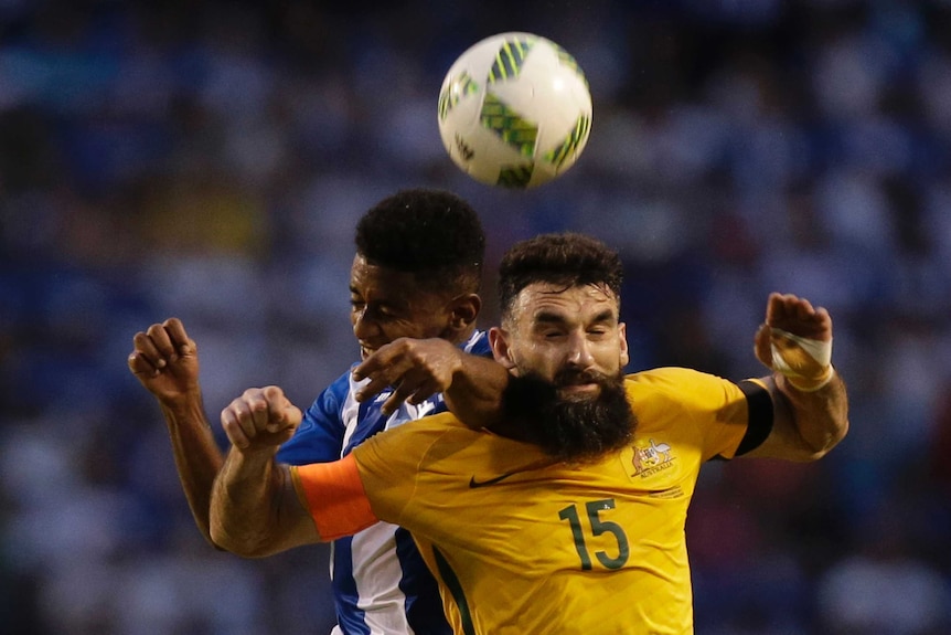 Mile Jedinak contests the ball against Honduras