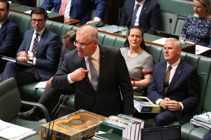 A man points to himself as he looks angrily across the chamber