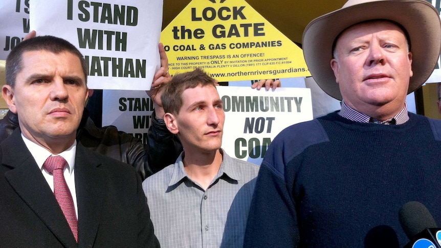 Environmental activist Jonathan Moylan (centre) stands outside the Downing Centre Courts in Sydney