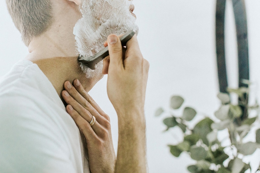 Man using mirror to shave