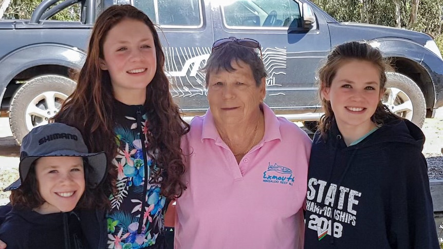 A photo of an older woman with two young girls and a young boy smiling at the camera