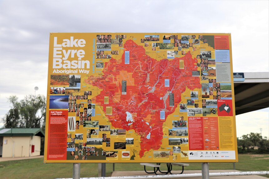 A large map showing traditional lands of the first people of the lake eyre basin stands in a caravan park.