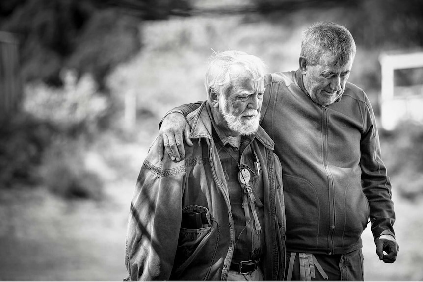 Two older men walk together in a photo from Men with Heart exhibition.