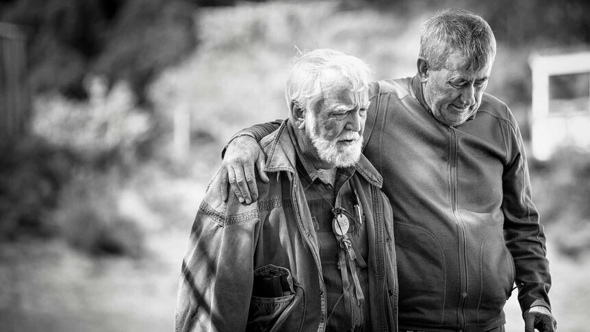 Two older men walk together in a photo from Men with Heart exhibition.