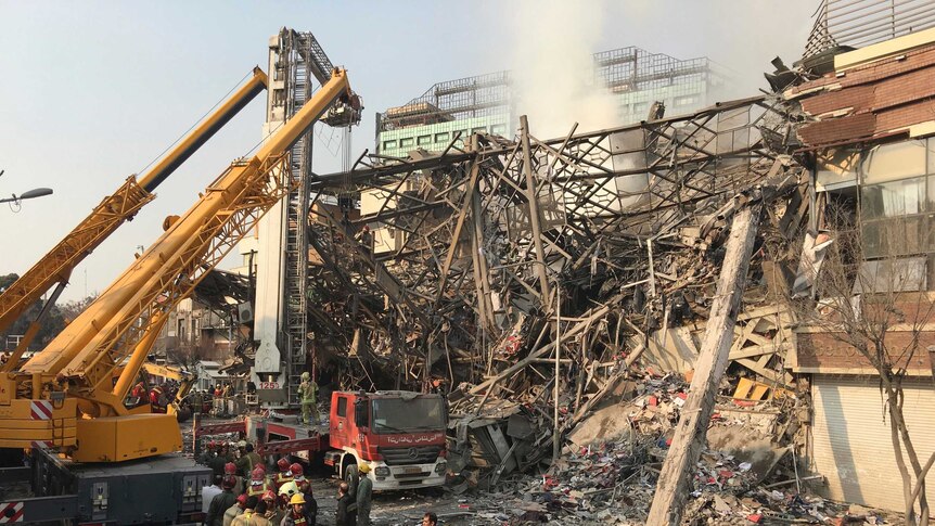 Iranian firefighters work at the scene of the collapsed Plasco building.