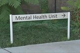 A sign in a garden points to the mental health unit