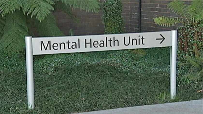 A sign in a garden points to the mental health unit