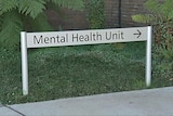 A sign in a garden points to the mental health unit