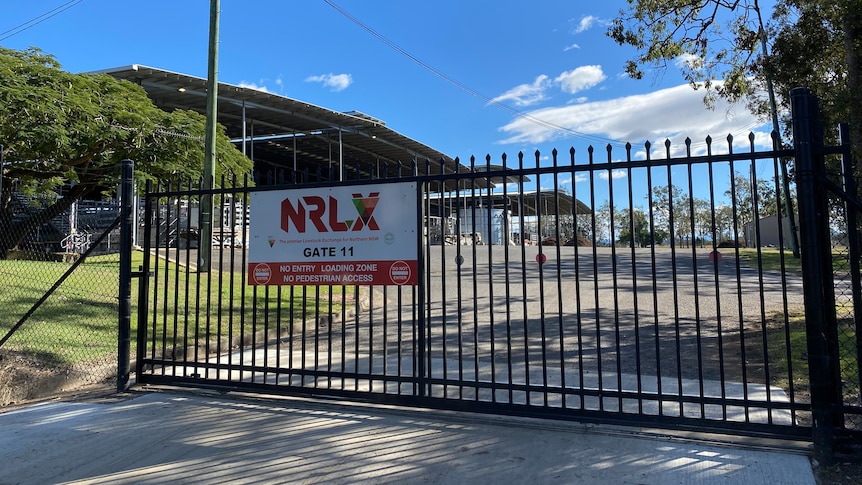 Black steel gates closed with an NRLX sign on front.