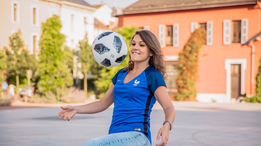 Woman kicks soccer ball into the air