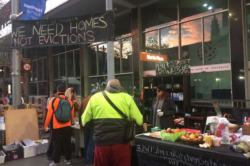 Outdoor kitchen and sign reading "We need homes not evictions".