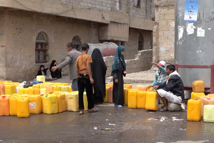 People queue on the street for water