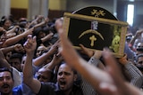 Egyptian Coptic men carry the coffin of a victim of deadly clashes. (AFP: Mohammed Hossam)