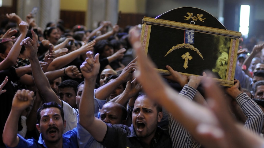 Egyptian Coptic men carry the coffin of a victim of deadly clashes. (AFP: Mohammed Hossam)