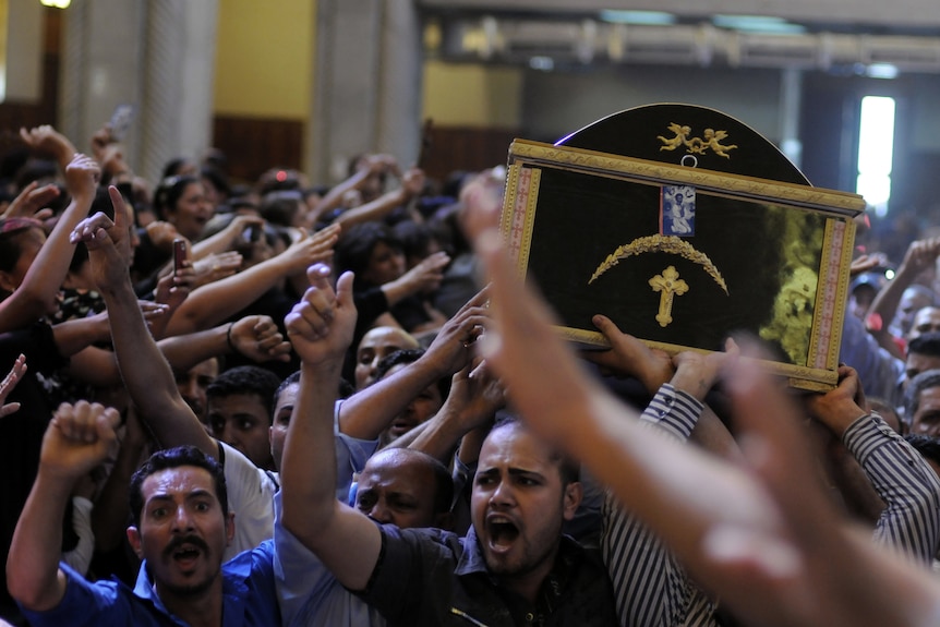 Egyptian Coptic men carry the coffin of a victim of deadly clashes. (AFP: Mohammed Hossam)