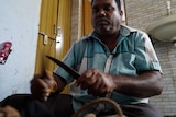 Dalit man, Somu Bhay Solanki, holding the knives he once used skin cattle.