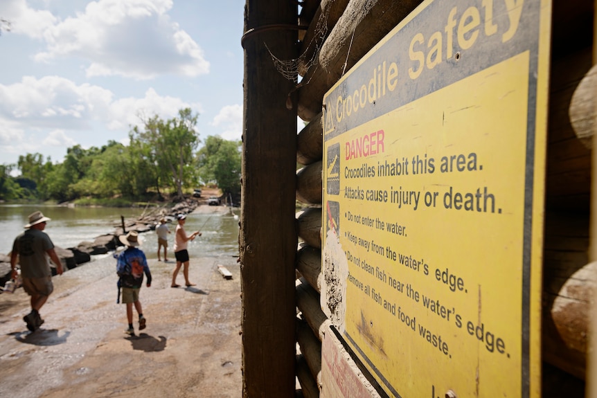 A crocodile warning sign is seen on a fence at Cahill's Crossing.