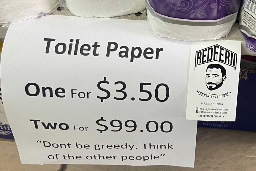 Close up of toilet paper on the shelf in a supermarket with price tag, 'one for $3.50, two for $99, don't be greedy'