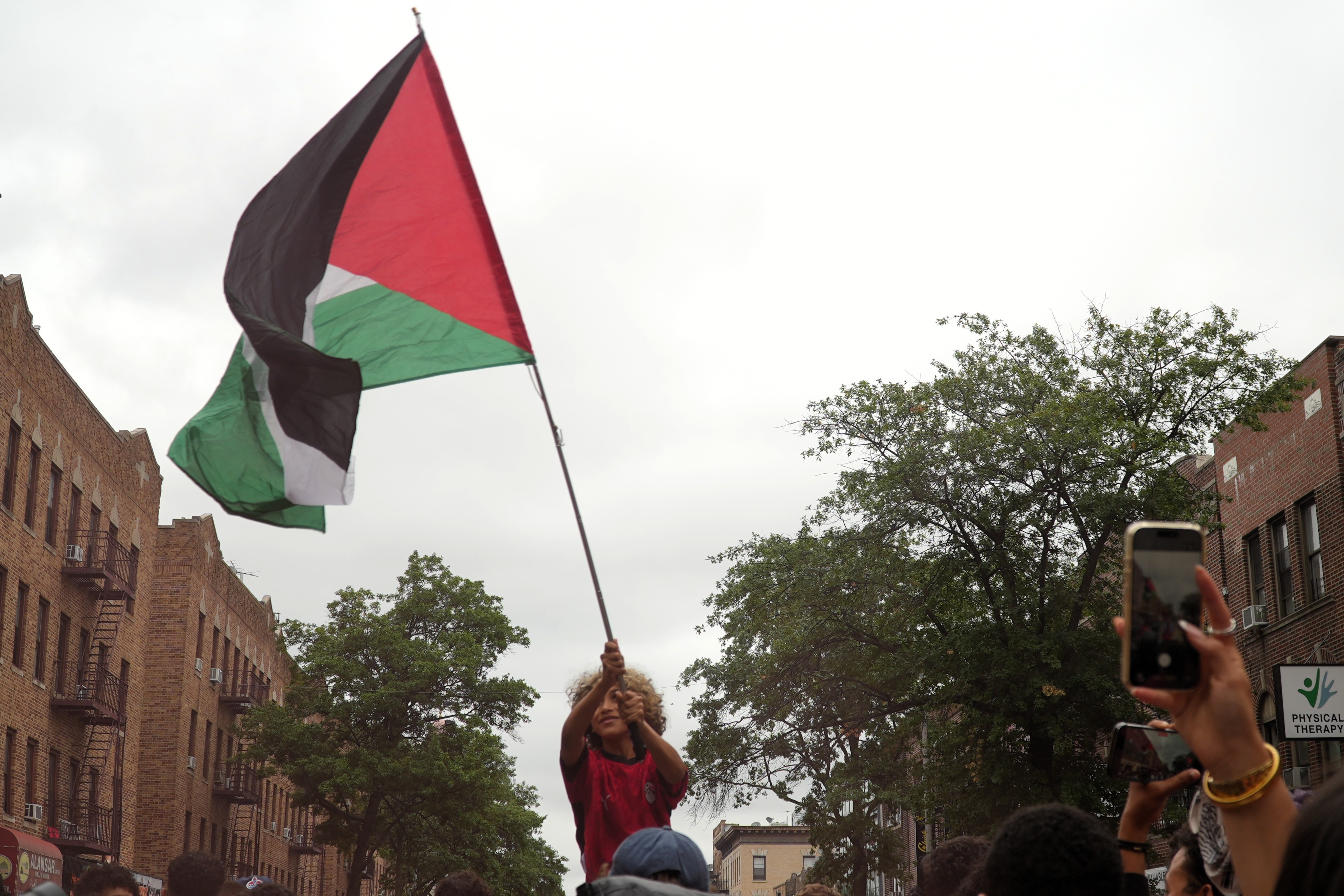 A young boy waves a Palestine flag