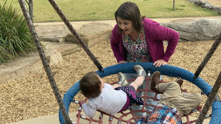 Rachael McConaghie pushes her children on a swing in the playground.
