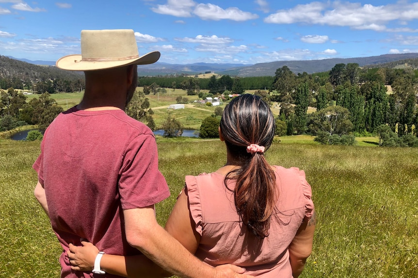 A photo of a couple's backs, looking out to the distance