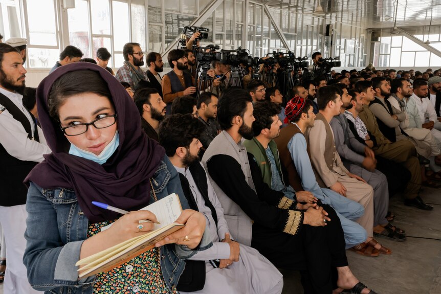 An Afghan female journalist attends a Taliban officials news conference.