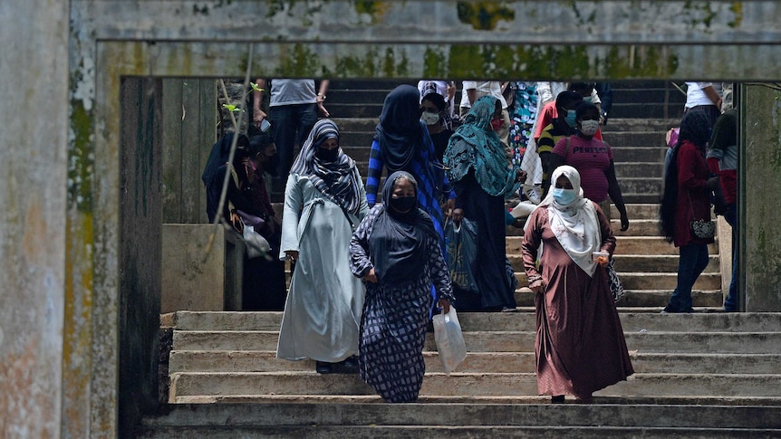 Burqa clad Muslim women climb down a flight of stairs in Sri Lanka
