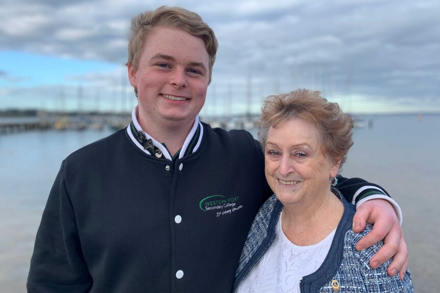 Ryan Hicklin stands with his arm around his grandmother, Di Hicklin on the beach.