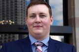 A medium close up image of WA Liberal Democrat MP Aaron Stonehouse, in a blue suit and checked tie.