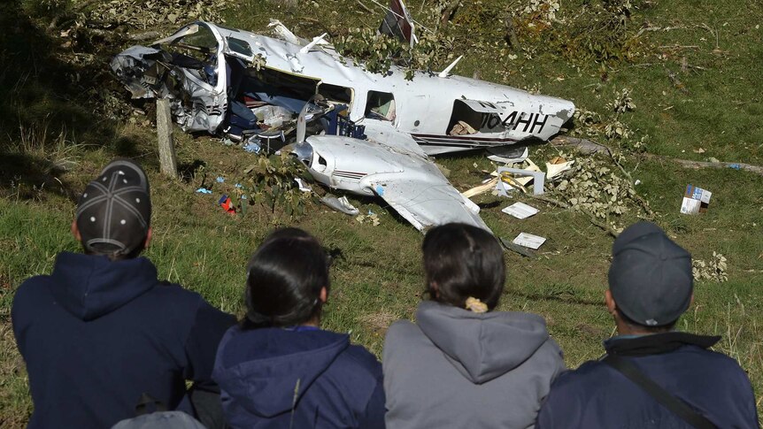 People look at wreckage of movie crew plane in Colombia