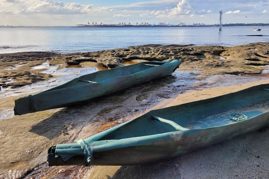 Two metal canoes at a beach