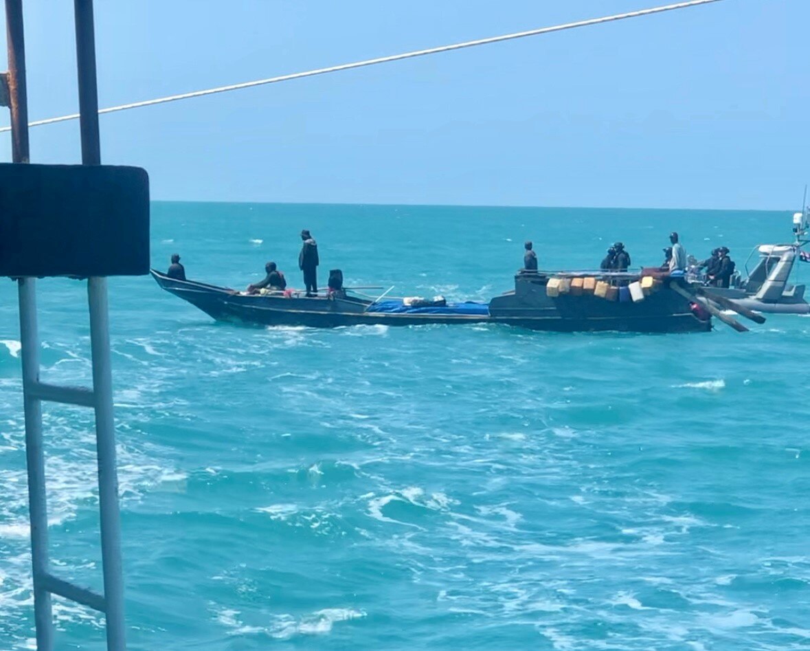 An illegal fishing boat, with an Australian Border Force boat in the background