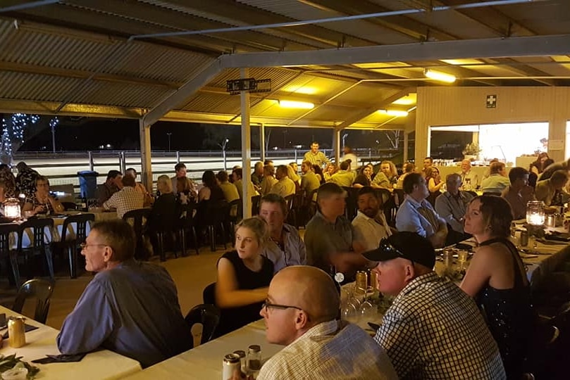 people sitting at tables in a building at the showgrounds
