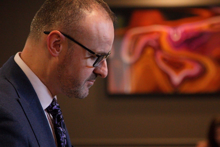 ACT Chief Minister Andrew Barr looks down at a press conference.