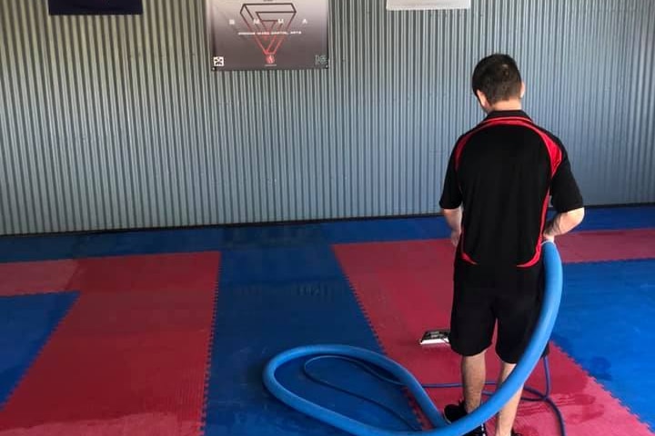 An UltraBright employee cleans a local gym