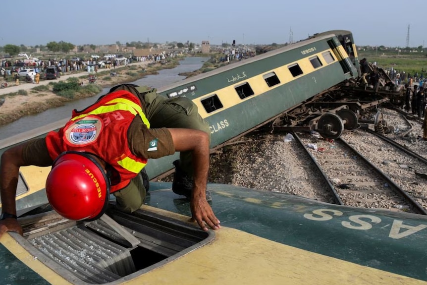 A rescue worker searches for victims in a trainwreck