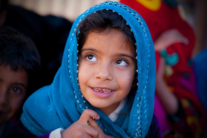 A young refugee smiles for camera