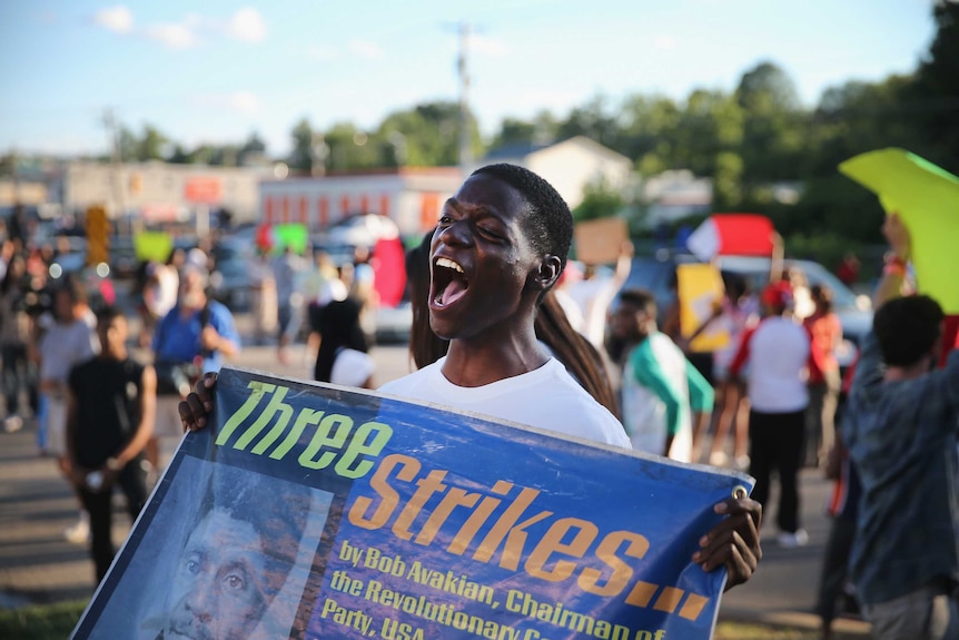 A protester in Ferguson holds up a sign