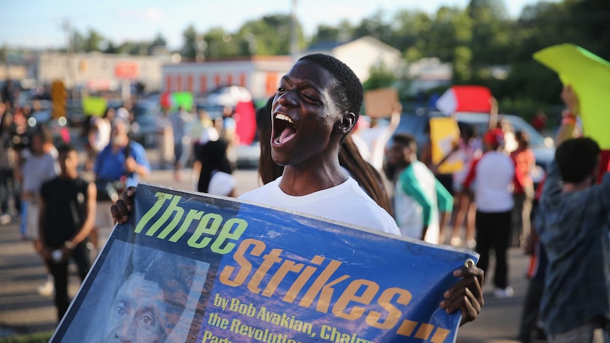 A protester in Ferguson holds up a sign