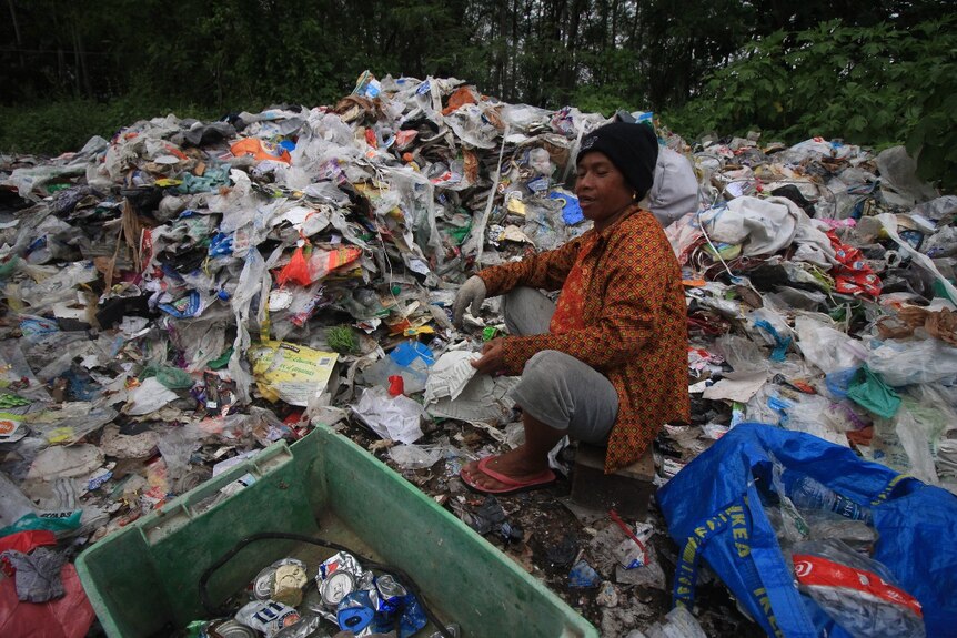 A man sitting on a pile of garbage