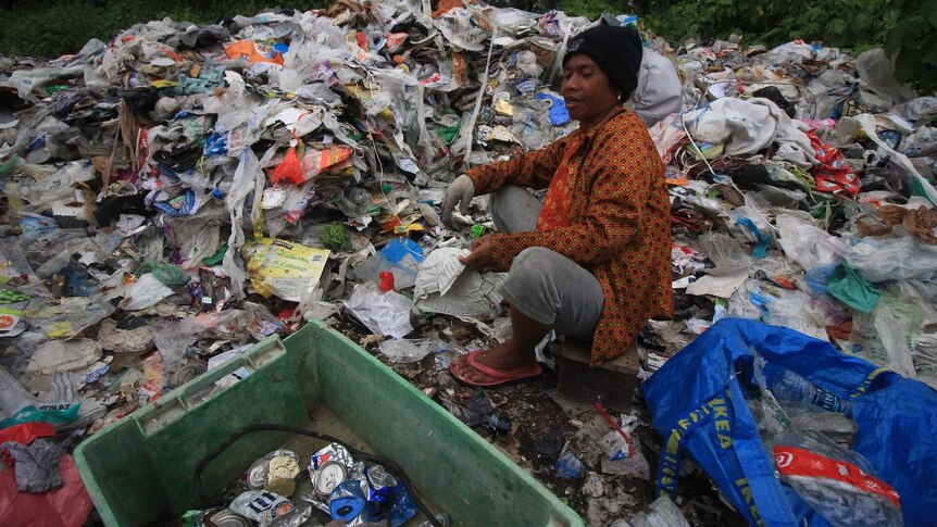 A man sitting on a pile of garbage