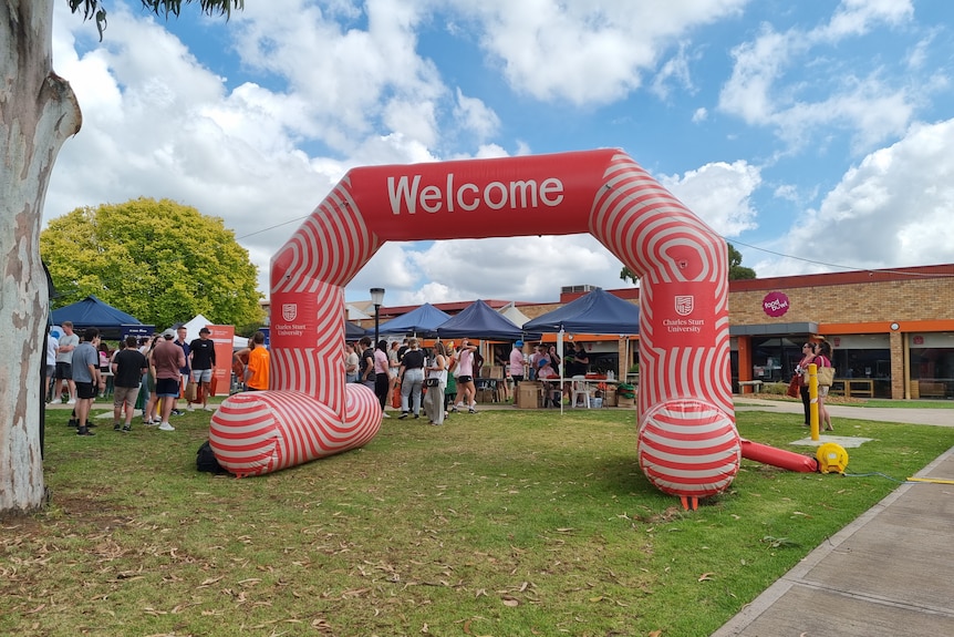 An orange and white inflatable welcome sign is set up at Charles Sturt University in Bathurst for Orientation Week