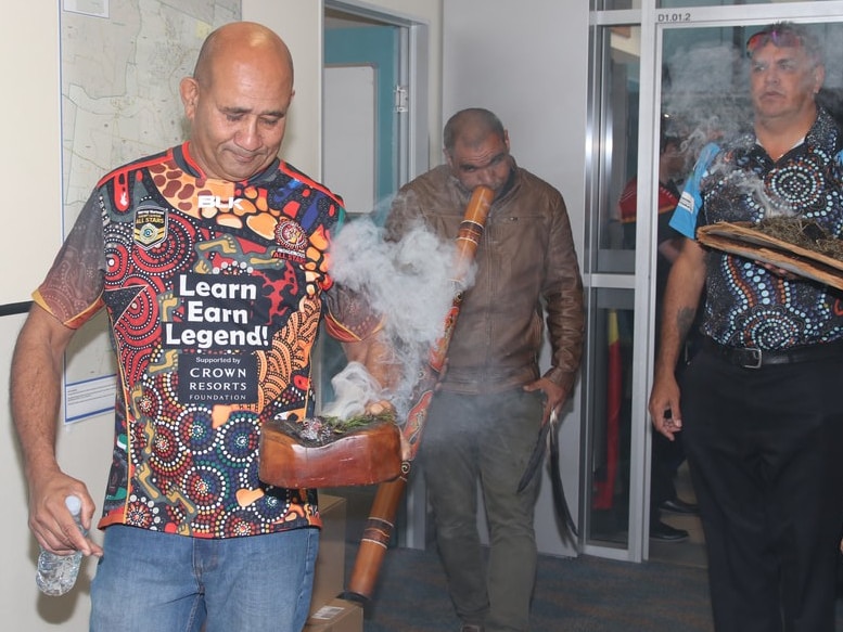 Indigenous men conducting a smoking ceremony