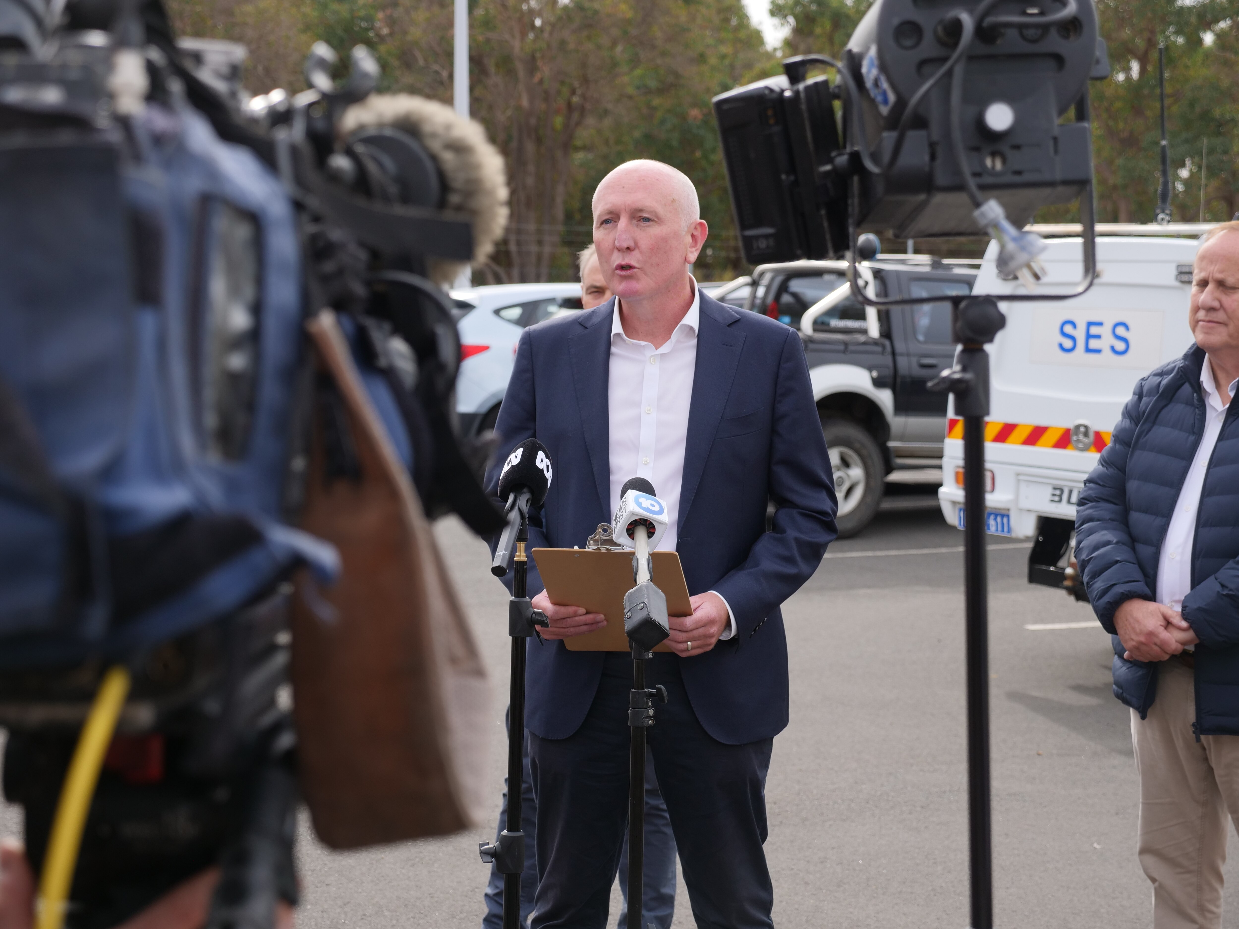 Several people speak to the media outside.