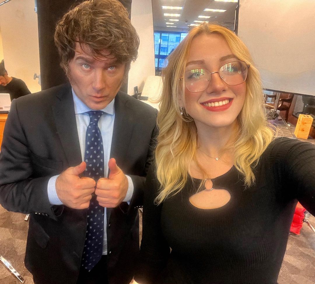 A man gives the camera the thumbs up posing next to a woman.