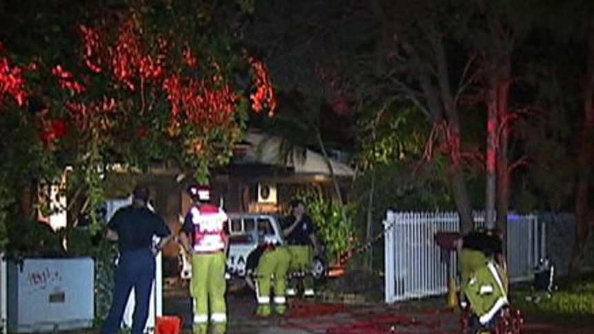 Firefighters inspect a three-bedroom house which was engulfed in flames in Darwin