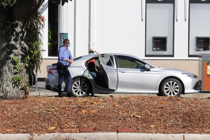 A woman sits in an unmarked car